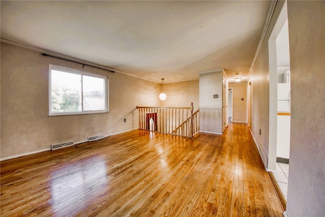 unfurnished room featuring light wood-type flooring and ornamental molding