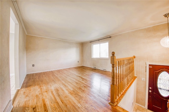 interior space featuring ornamental molding, an inviting chandelier, and light hardwood / wood-style floors