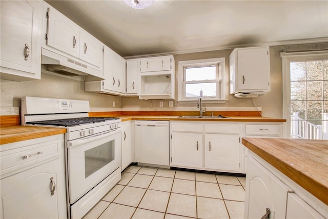 kitchen featuring white appliances, sink, light tile patterned floors, and white cabinets