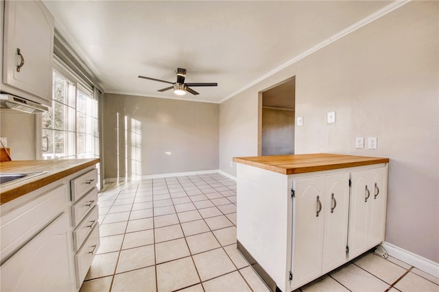 kitchen with ceiling fan, white cabinets, butcher block counters, light tile patterned flooring, and ornamental molding