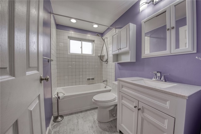 full bathroom with tiled shower / bath, vanity, toilet, and hardwood / wood-style flooring