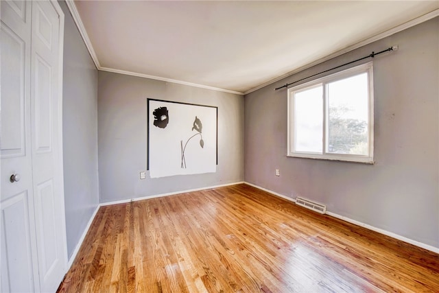 unfurnished room featuring crown molding and light hardwood / wood-style flooring