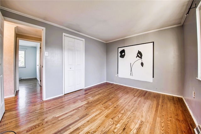 unfurnished bedroom featuring ornamental molding and light hardwood / wood-style floors