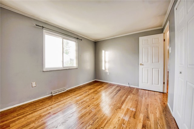 unfurnished room with light wood-type flooring and ornamental molding