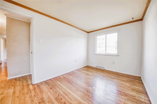 spare room featuring crown molding and light hardwood / wood-style flooring