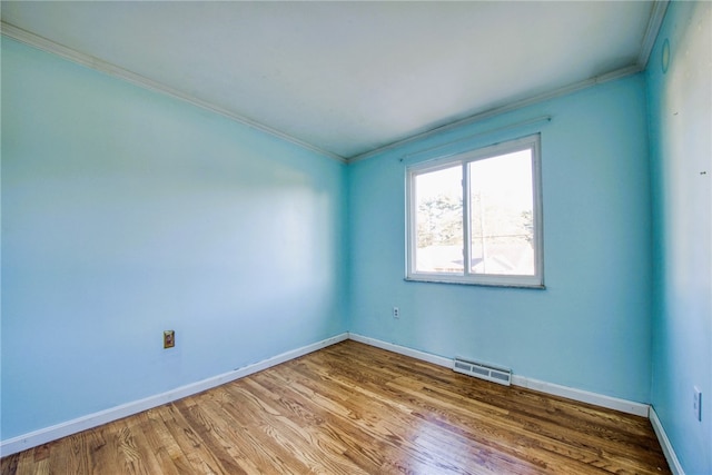 spare room featuring crown molding and hardwood / wood-style flooring