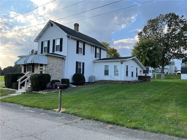 view of side of home with a yard and central AC unit