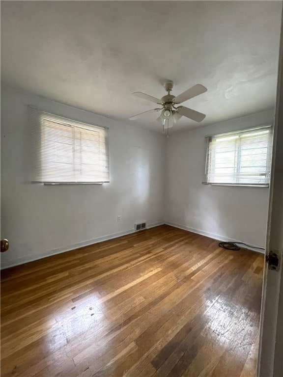 spare room featuring wood-type flooring and ceiling fan