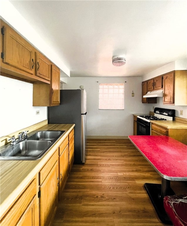 kitchen with dark hardwood / wood-style floors, white gas range oven, and sink