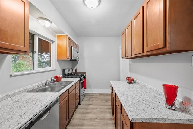 kitchen featuring appliances with stainless steel finishes, sink, and light hardwood / wood-style floors