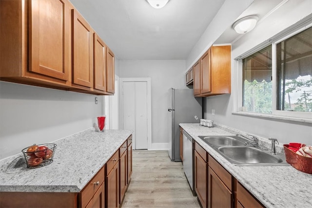 kitchen with dishwasher, light wood-type flooring, and sink