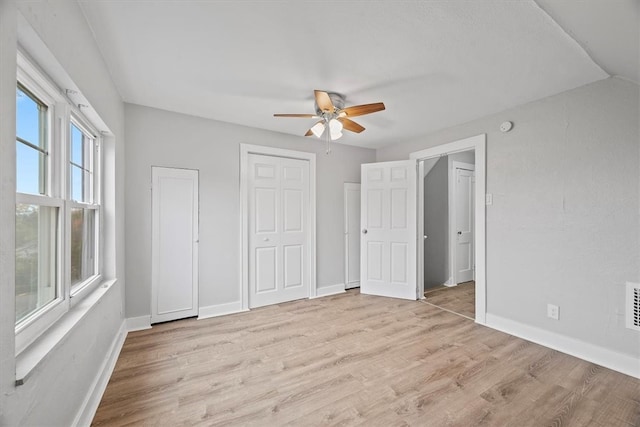 unfurnished bedroom with light wood-type flooring, ceiling fan, and vaulted ceiling