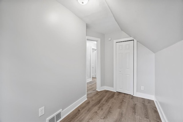 additional living space with light wood-type flooring and lofted ceiling