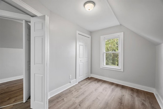 additional living space with lofted ceiling and light hardwood / wood-style floors