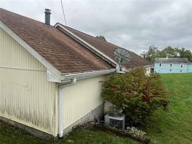 view of property exterior with a yard and central AC