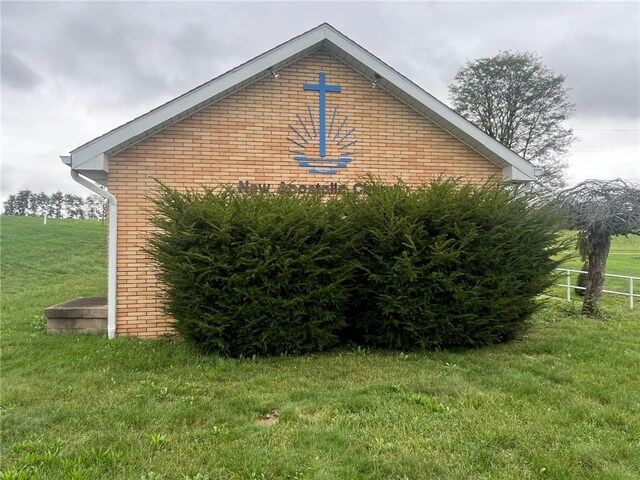 view of side of home with a yard