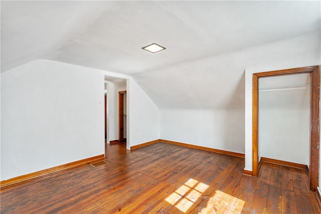 additional living space featuring dark hardwood / wood-style floors and vaulted ceiling