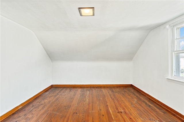 bonus room featuring vaulted ceiling, dark hardwood / wood-style flooring, and a wealth of natural light