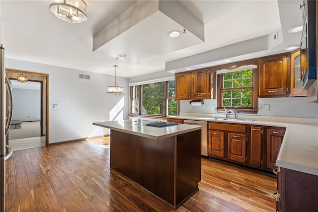 kitchen with a kitchen island, stainless steel appliances, dark wood-type flooring, sink, and a chandelier