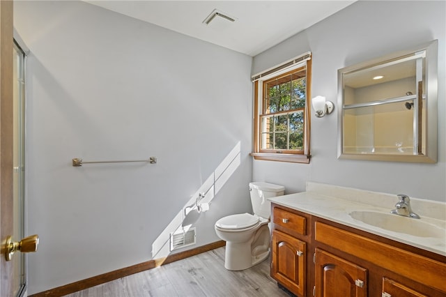 bathroom featuring vanity, toilet, a shower with door, and hardwood / wood-style flooring