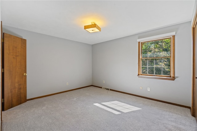 spare room featuring light colored carpet