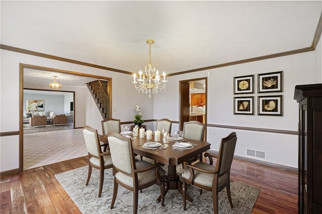 dining space with ornamental molding, a chandelier, and dark hardwood / wood-style flooring