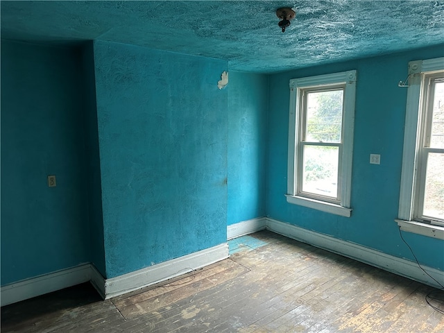 unfurnished room featuring plenty of natural light and hardwood / wood-style floors