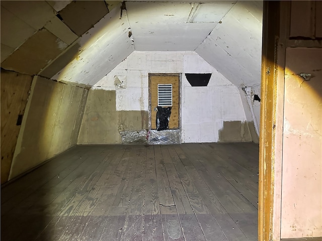 additional living space with hardwood / wood-style flooring and lofted ceiling