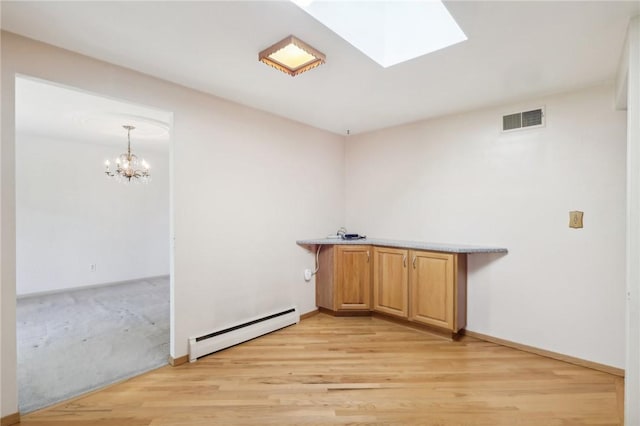 washroom featuring a skylight, a baseboard heating unit, a chandelier, and light hardwood / wood-style flooring