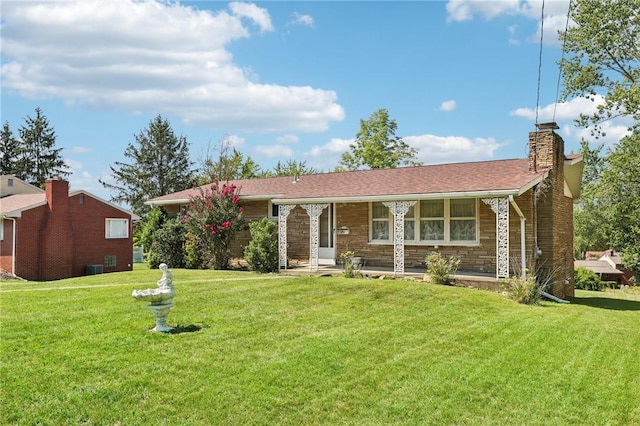 ranch-style home featuring covered porch, a chimney, stone siding, and a front yard