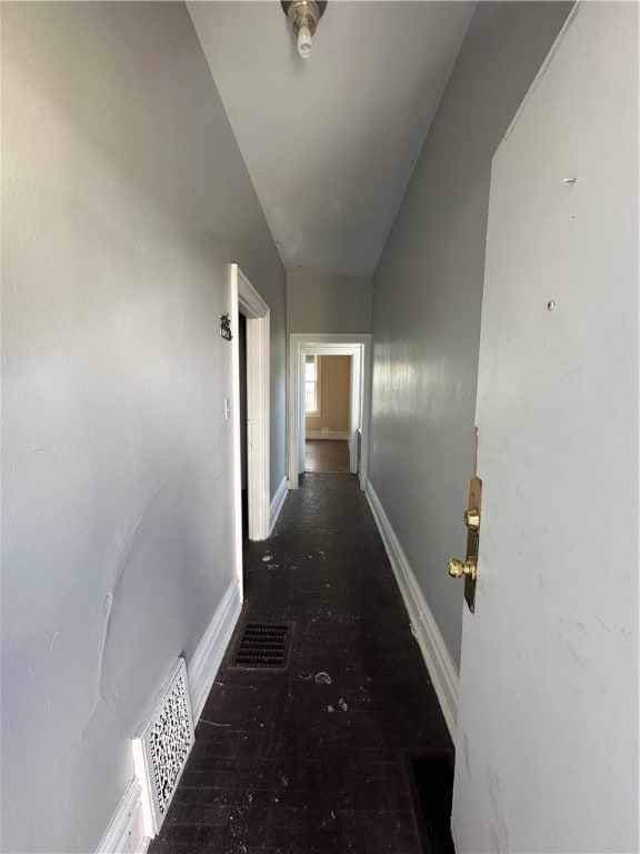 hall with vaulted ceiling and dark hardwood / wood-style floors