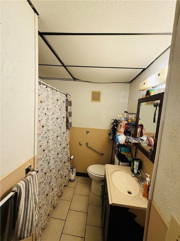 bathroom with tile patterned flooring, vanity, and toilet