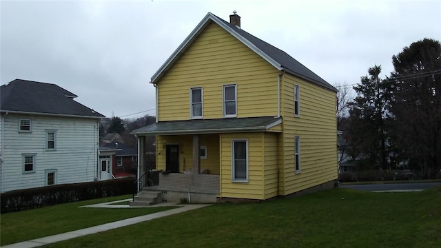 rear view of property featuring a yard