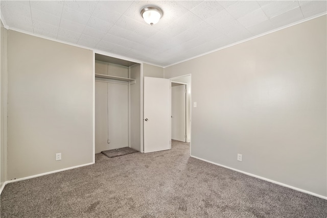 unfurnished bedroom featuring ornamental molding, a closet, and carpet flooring