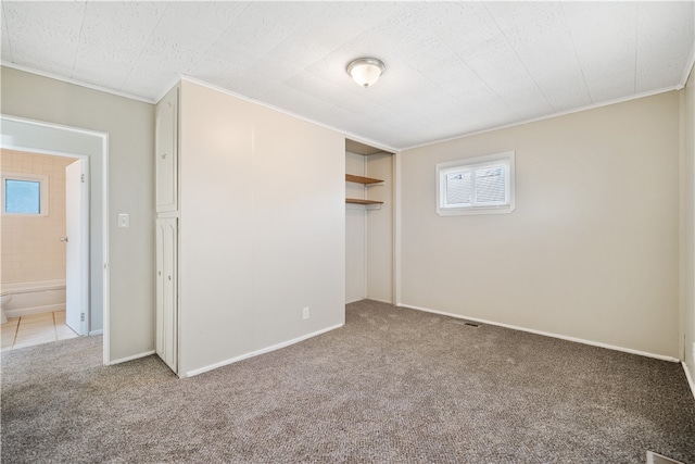 unfurnished bedroom featuring light carpet, a closet, ornamental molding, and multiple windows