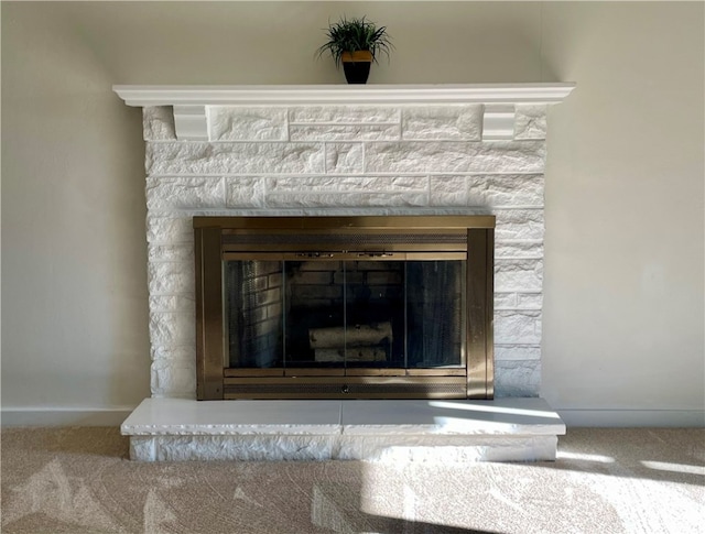 room details featuring carpet and a stone fireplace