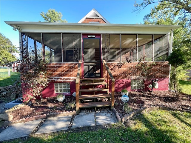 rear view of property featuring a sunroom