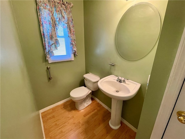 bathroom featuring wood-type flooring and toilet