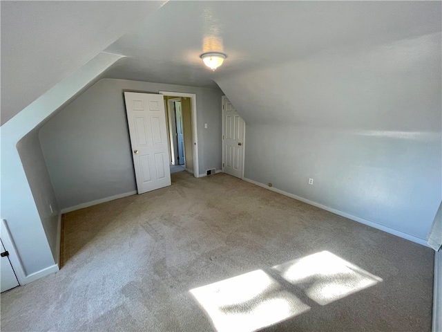 additional living space with lofted ceiling and light carpet