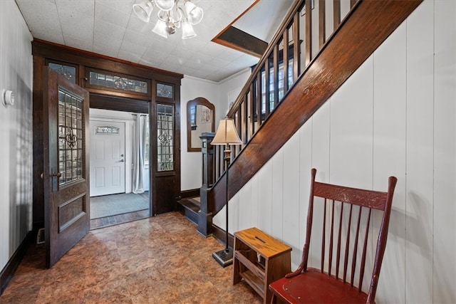 foyer with wood walls and a chandelier