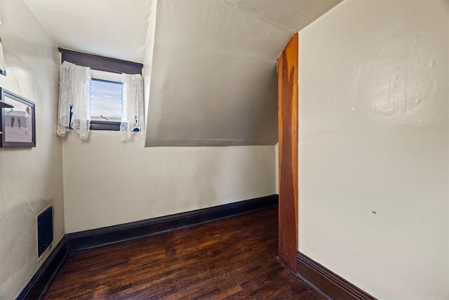 bonus room with vaulted ceiling and dark hardwood / wood-style flooring