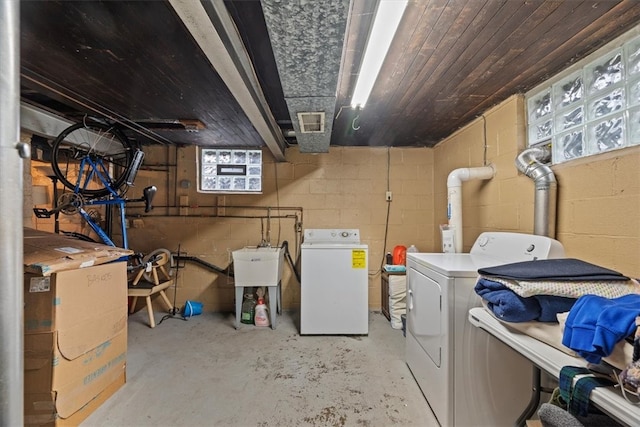 clothes washing area featuring washing machine and dryer and sink