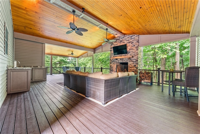 wooden deck featuring an outdoor living space with a fireplace and ceiling fan