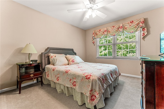 bedroom featuring ceiling fan, light carpet, and multiple windows