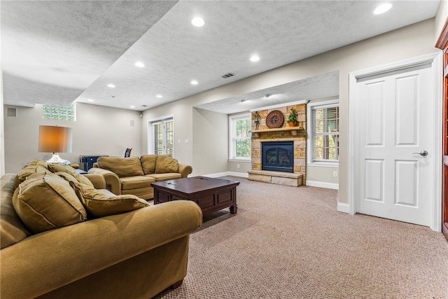 carpeted living room with a fireplace and a textured ceiling