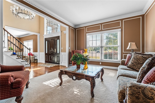 living room with ornamental molding, light wood-type flooring, and a chandelier