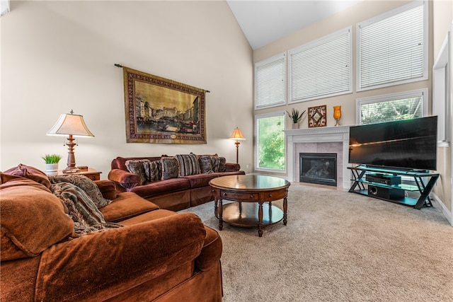 living room with high vaulted ceiling, a tiled fireplace, and carpet floors