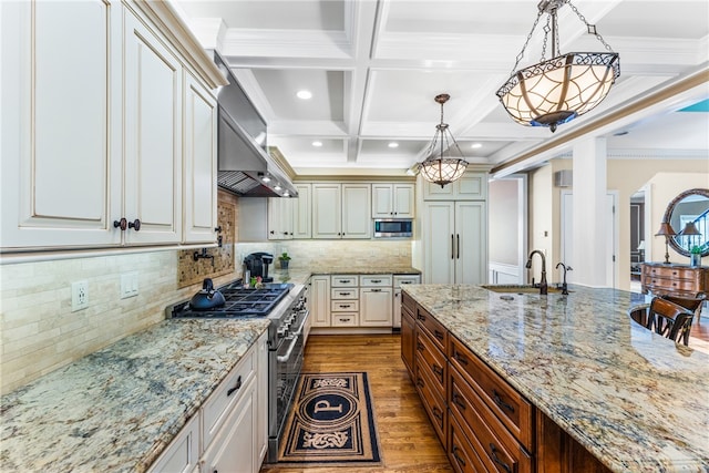 kitchen featuring beam ceiling, decorative light fixtures, coffered ceiling, stainless steel appliances, and dark hardwood / wood-style flooring