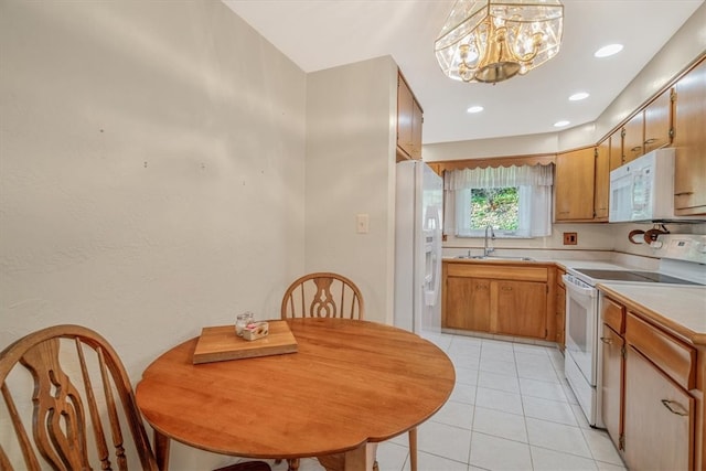 kitchen featuring a chandelier, white appliances, sink, hanging light fixtures, and light tile patterned floors