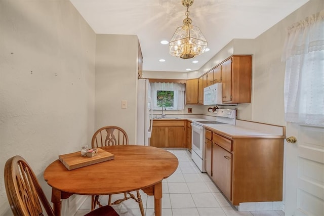 kitchen with light tile patterned floors, sink, white appliances, decorative light fixtures, and an inviting chandelier